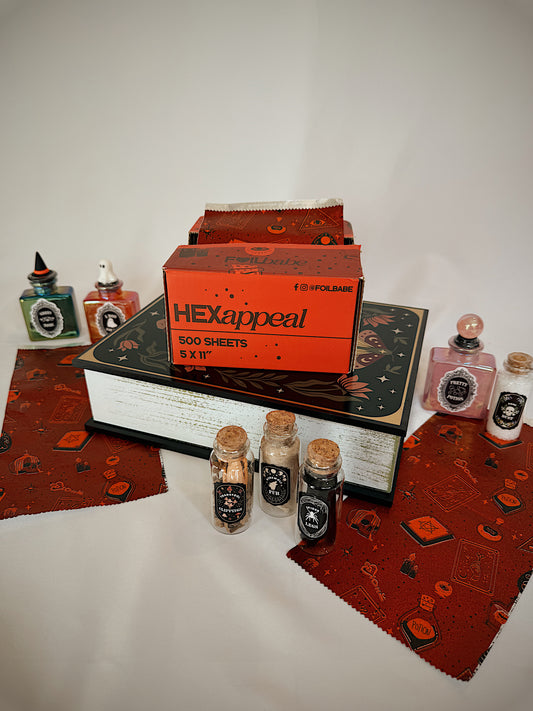 Collection of stationery items including a box labeled 'HEXappeal' on a textured surface.